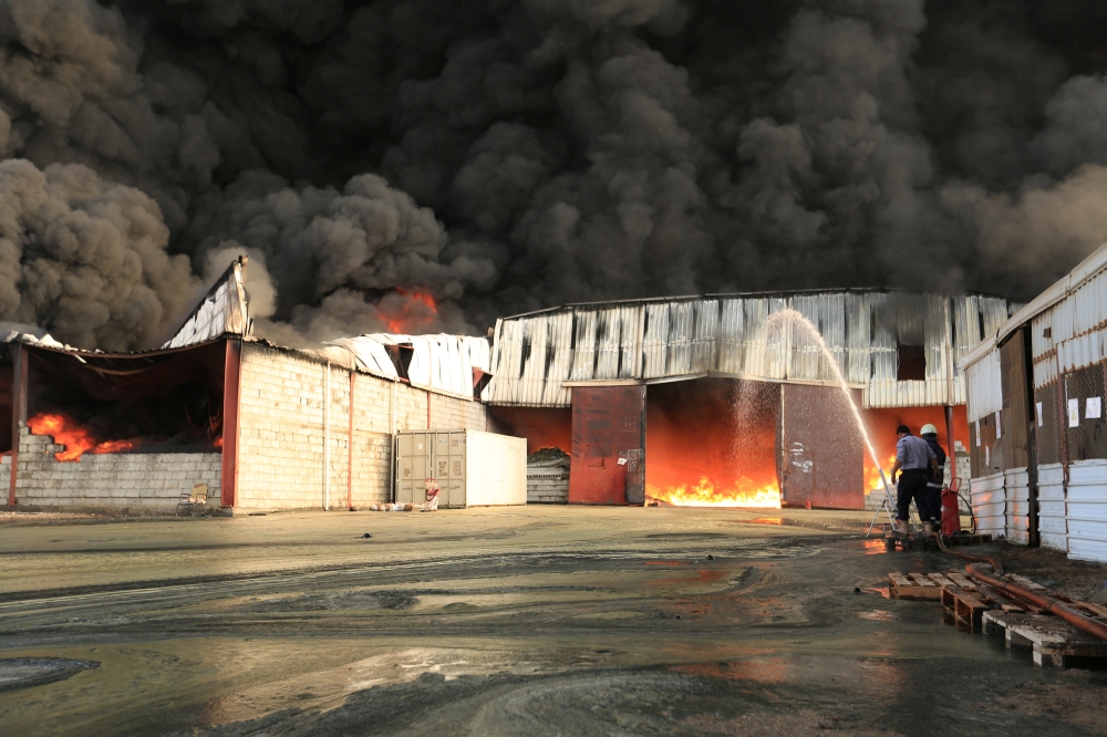 Firefighters try to extinguish a fire engulfing warehouse of the World Food Programme in Hodeida, Yemen March 31, 2018. REUTERS/Abduljabbar Zeyad
