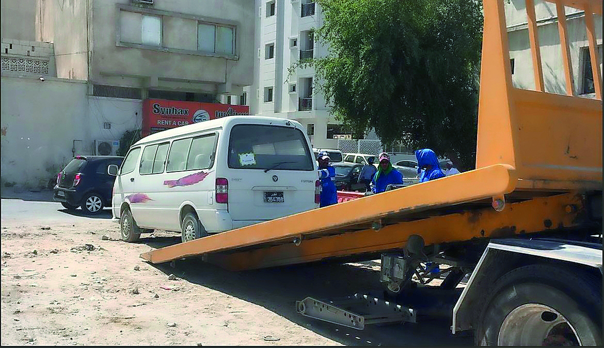 Workers remove abandoned vehicles in Doha. 