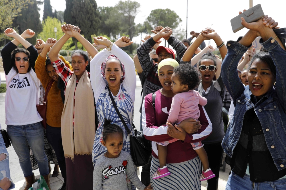 African migrants and Israelis demonstrate in the city of Tel Aviv on April 3, 2018, against the Israeli government's policy to forcibly deport African refugees and asylum seekers. / AFP / MENAHEM KAHANA 