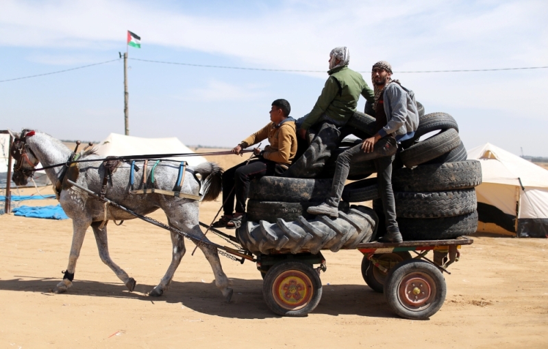 Palestinian activists collect tyres to be burnt along Israel-Gaza border, in the southern Gaza Strip April 2, 2018.  Reuters/Ibraheem Abu Mustafa
