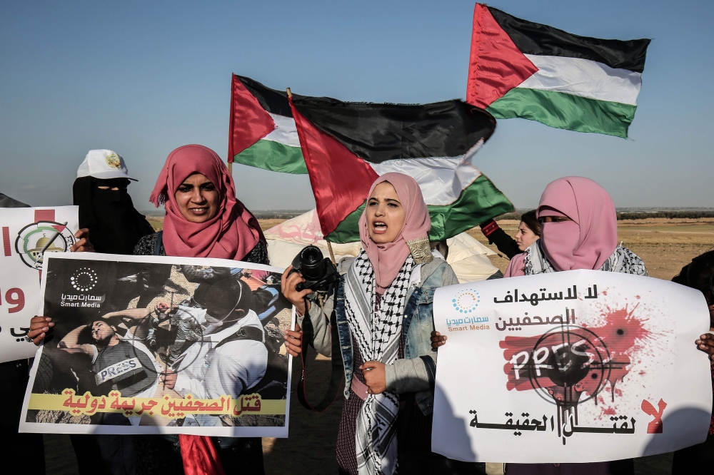 Palestinian Journalists take part in a protest against the killing of fellow journalist Yasser Murtaja, near the Israel-Gaza border, in Rafah in the southern Gaza Strip, on April 8, 2018.  AFP / Said Khatib
