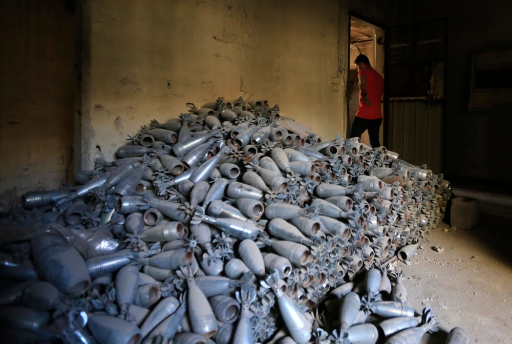 A Syrian man walks past abandoned shells in Douma on the outskirts of Damascus on April 16, 2018 during an organised media tour after the Syrian army declared that all anti-regime forces have left Eastern Ghouta, following a blistering two month offensive