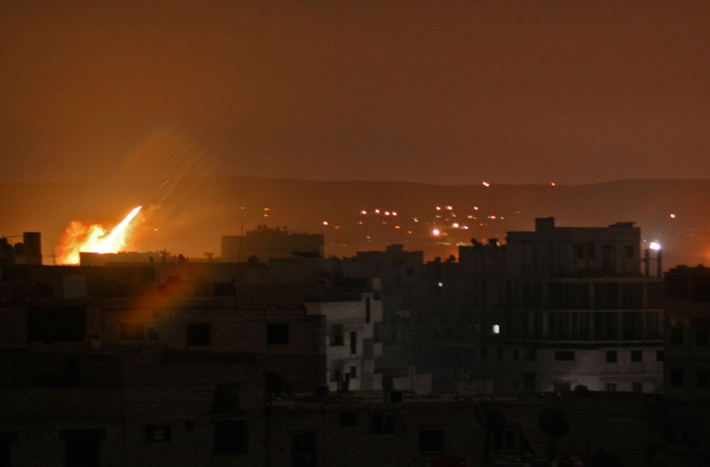 A picture taken in the Yarmuk Palestinian refugee camp in southern Damascus on April 24, 2018 shows fire billowing in the area during Syrian army shelling. / AFP / Rami al SAYED
