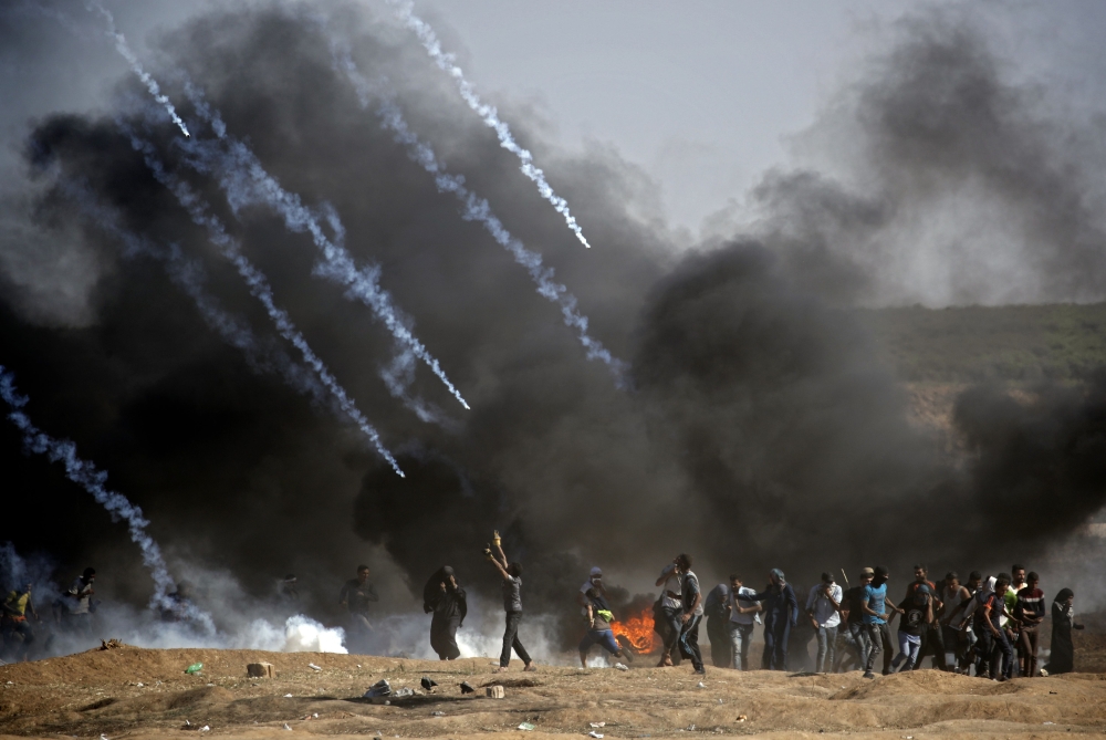 Tear gas is fired at protestors during clashes with Israeli forces near the border between the Gaza strip and Israel, east of Gaza City on May 14, 2018, following the the controversial move to Jerusalem of the United States embassy. AFP / Thomas Coex
