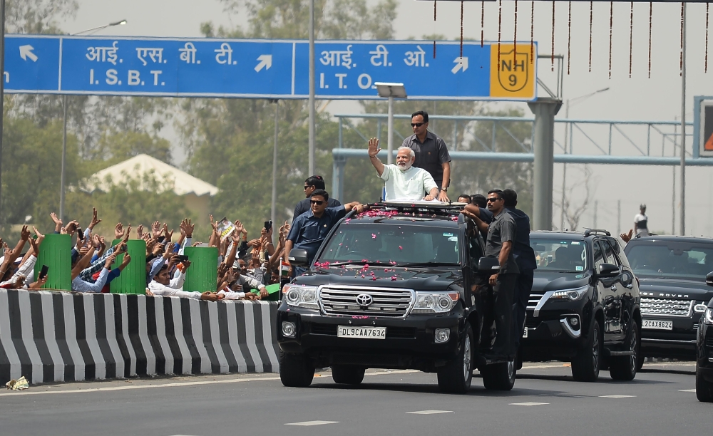 Indian Prime Minister Narendra Modi waves to supporters during a road-show event in New Delhi on May 27, 2018. / AFP / Sajjad HUSSAIN
