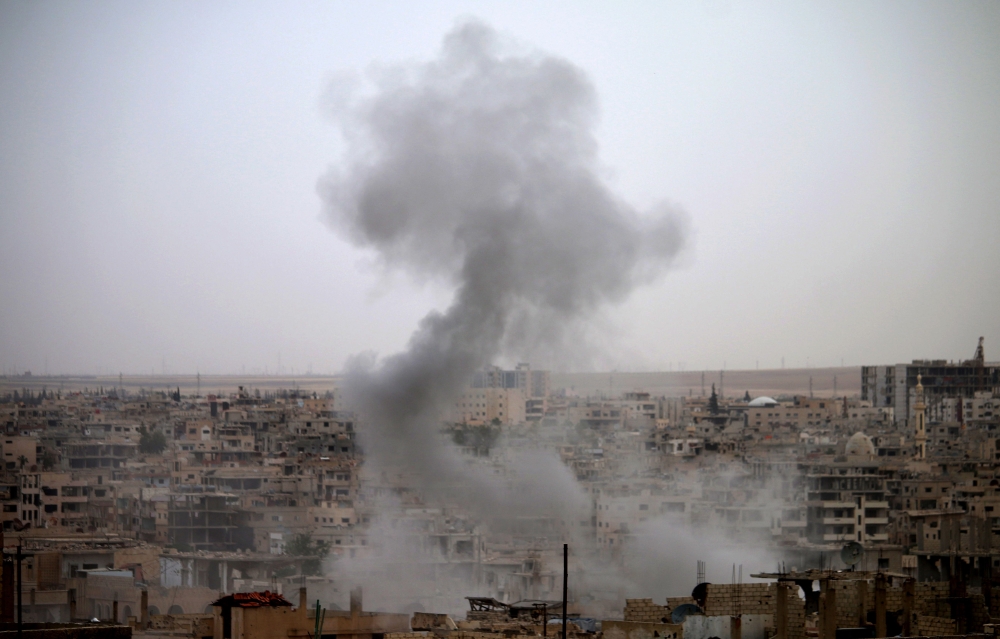 Smoke rises from buildings in a rebel-held neighbourhood of Daraa in southern Syria following reported shelling by the regime on May 22, 2018. / AFP / Mohamad ABAZEED

