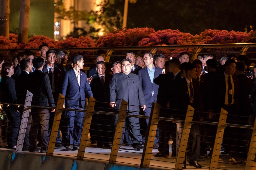 North Korean leader Kim Jong-Un (C) walks on the Jubilee bridge during a tour in Singapore on June 11, 2018.  AFP / Nicholas Yeo