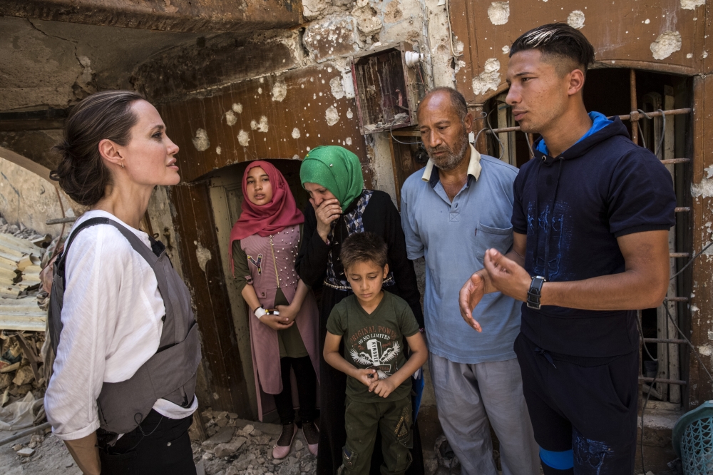 US actress and the UN refugee agency UNHCR (United Nations High Commissioner for Refugees) Special Envoy Angelina Jolie (L) chats with residents on needs of people and reconstruction works during her visit in Iraq’s northern city of Mosul on June 16, 2018
