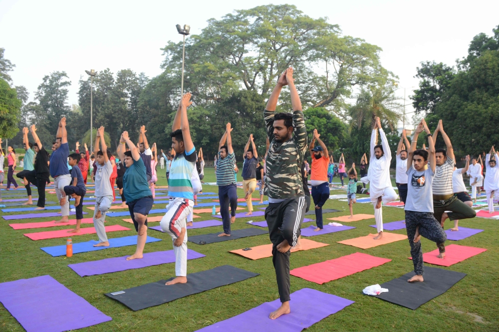 Indian yoga practitioners take part in a yoga session ahead of International Yoga Day at a park in Amritsar, India. AFP / NARINDER NANU