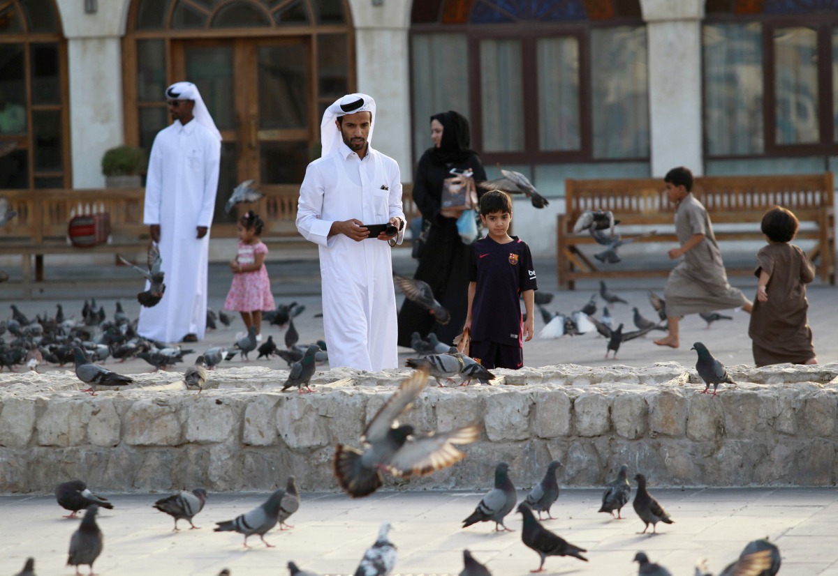 FILE PHOTO:  People look at pigeons at Souq Waqif market in Doha, June 6, 2017. Reuters / Naseem Zeitoon