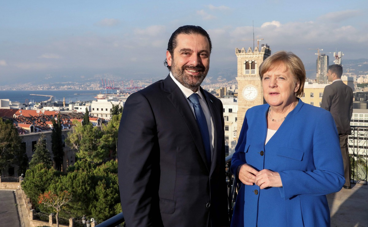 A handout picture provided by the Lebanese photo agency Dalati and Nohra on June 21, 2018 shows Lebanese Prime Minister Saad Hariri (C) and German Chancellor Angela Merkel (R) posing for a picture from a panoramic view overlooking the capital Beirut.