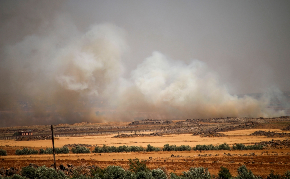 A picture taken on June 21, 2018 shows smoke plumes rising from Syrian regime bombardment on the town of Al-Mulayhah al-Sharqiyah in the eastern Daraa province countryside. AFP / Mohamad ABAZEED