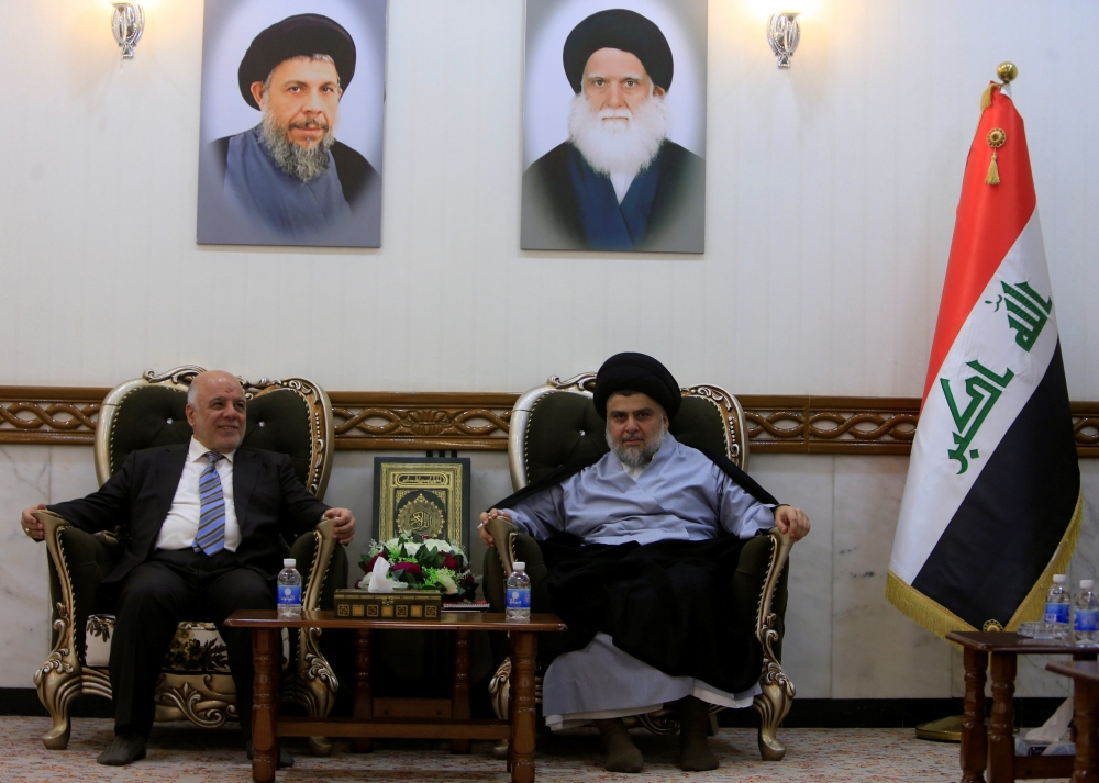 Iraqi Prime Minister Haider al-Abadi, who's political bloc came third in a May parliamentary election, (L) meets with cleric Moqtada al-Sadr, who's bloc came first, in Najaf, Iraq June 23, 2018. REUTERS/Alaa al-Marjani