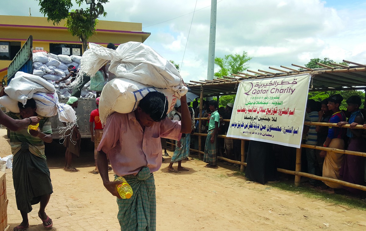 Rohingya refugees carry food aid of QC in Bangladesh. 