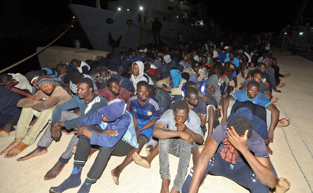Migrants wait at a naval base in Tripoli, after being rescued in the Mediterranean on June 24, 2018. Some five hundred African migrants were rescued in the Mediterranean by the country's coast guards on June 24, 2018, according to the Libyan navy. / AFP /