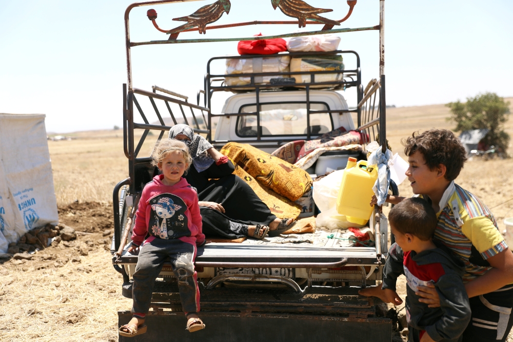 Internally displaced girl from Deraa province sits at a back of a truck near the Israeli-occupied Golan Heights in Quneitra, Syria July 11, 2018. Reuters/Alaa Al-Faqir