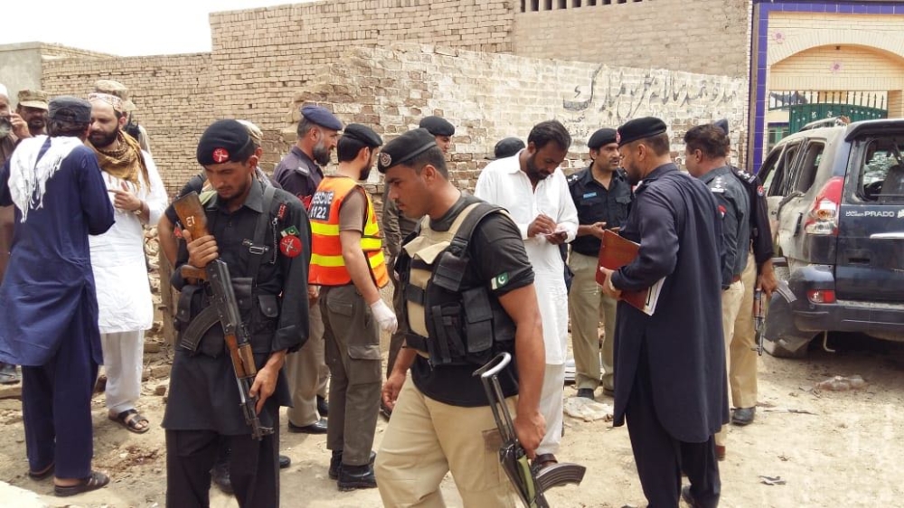 Rescue 1122 members and police officers inspect a damaged vehicle after a suicide bomber blew himself up near the vehicle of Ikramullah Gandapur in Looni Darbar area of Dera Ismail Khan district, when he was on his way for an election rally in the area,” 