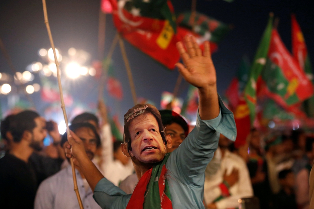 A supporter of Imran Khan, chairman of the Pakistan Tehreek-e-Insaf (PTI), political party, wears a mask and dance on party songs during a campaign rally ahead of general elections in Karachi, Pakistan July 22, 2018. (REUTERS/Akhtar Soomro/File Photo)