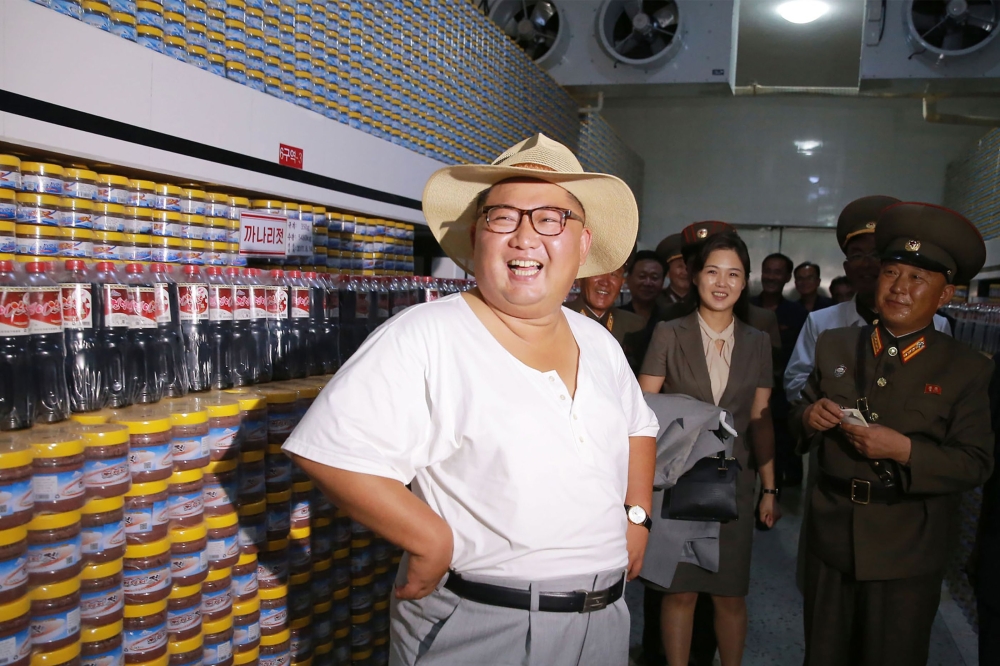 This undated picture released by North Korea's official Korean Central News Agency on August 8, 2018 via KNS shows North Korean leader Kim Jong Un (L) inspecting the Kumsanpho Fish Pickling Factory with his wife Ri Sol Ju (back C) in South Hwanghae Provin