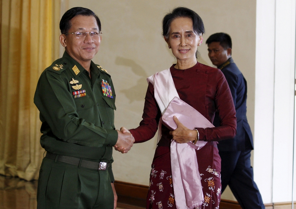 FILE PHOTO: Myanmar's Commander-in-Chief Min Aung Hlaing (L) shakes hands with National League for Democracy (NLD) party leader Aung San Suu Kyi before their meeting in Naypyitaw December 2, 2015. Reuters/Soe Zeya Tun

