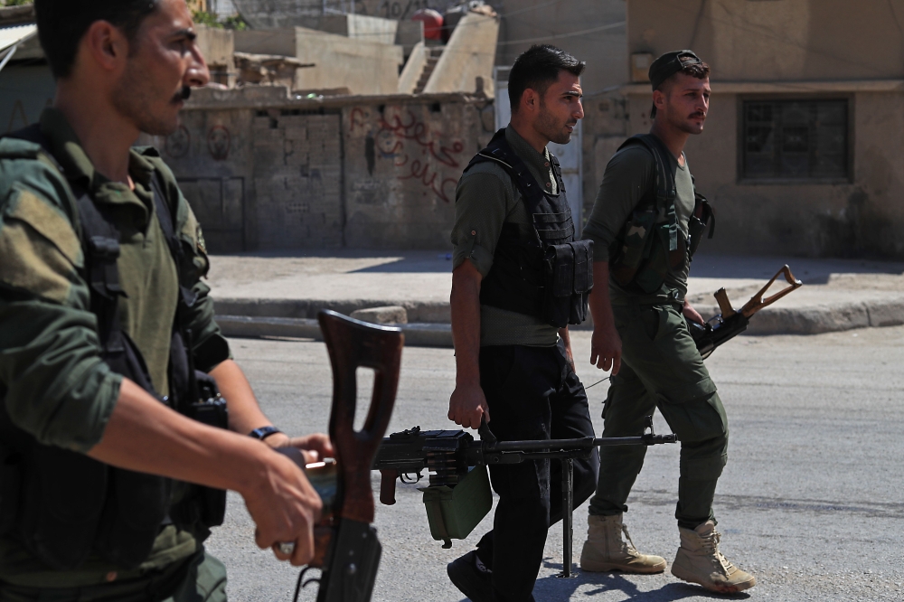 Members of the Asayish, Kurdish internal security police forces, arrive at the site of clashes with regime forces in Qamishly, northeastern Syria, on September 8, 2018.  AFP / Delil SOULEIMAN