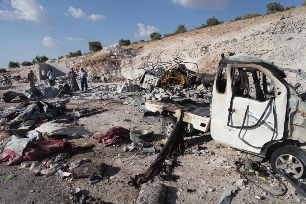 Syrians check the wreckage at a site in Hass town after an airstrike by pro-regime forces on the south of Idlib province on September 8, 2018.   AFP / Amer ALHAMWE
