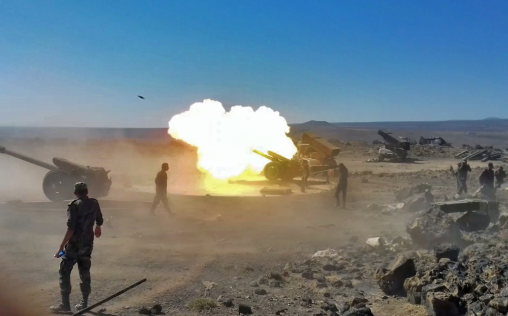 Syrian government artillery guns firing during bombardment against Islamic State (IS) group positions along the frontline in the Safa hills, in the southern Sweida province.  SANA
