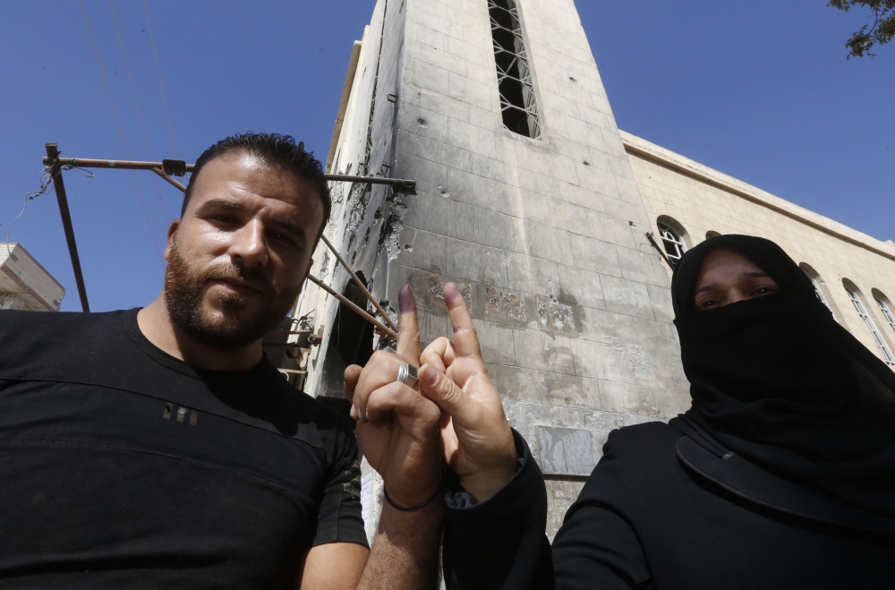 A man and a woman show their ink-stained index fingers after voting for Syria's first local elections since 2011, on September 16, 2018 in the southern Eastern Ghouta, on the eastern outskirts of the capital Damascus. AFP / LOUAI BESHARA