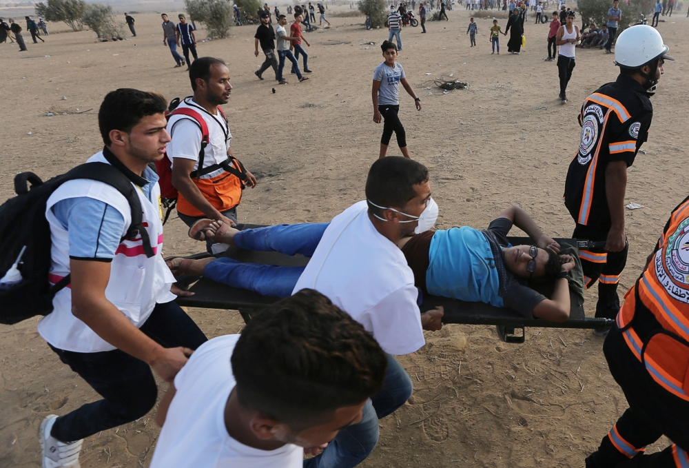 A wounded Palestinian is evacuated during a protest calling for lifting the Israeli blockade on Gaza and demanding the right to return to their homeland, at the Israel-Gaza border fence in the southern Gaza Strip October 12, 2018. Reuters/Ibraheem Abu Mus