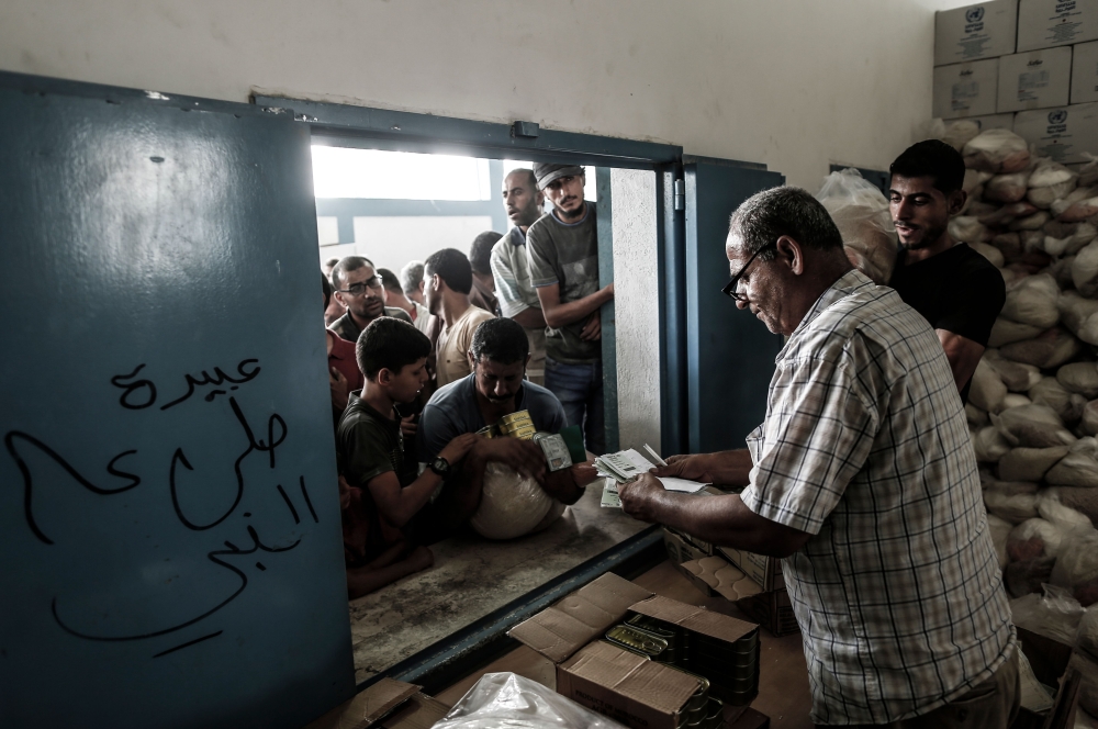 REPRESENTATIVE IMAGE: Palestinians receive aids at a United Nations food distribution centre in Jabalia refugee camp in the northern Gaza Strip, on August 8, 2018. (AFP/ Mahmud Hams)