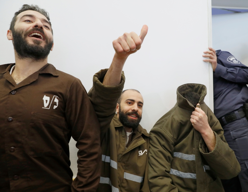French national Romain Franck (covering his face),  a worker at the French consulate, and Palestinian Moufak al-Ajluni and Mohamed Katout appear in court the southern Israeli city of Beer Sheva on March 19, 2018. AFP/Jack Guez