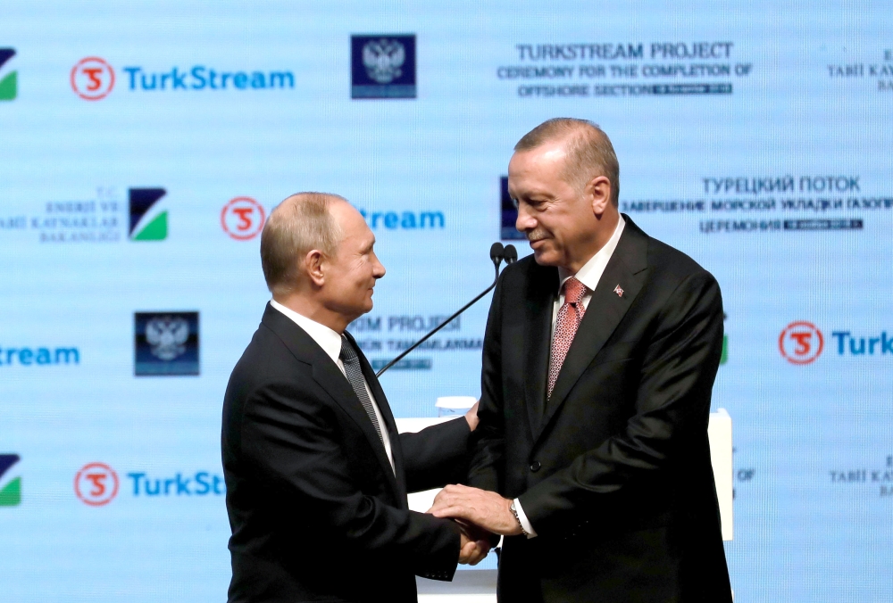 Turkish President Recep Tayyip Erdogan (R) shakes hands with Russian President Vladimir Putin (L) as they attend a ceremony commemorating completion of sea section works for TurkStream natural gas project on November 19, 2018 at Istanbul Congress Center (