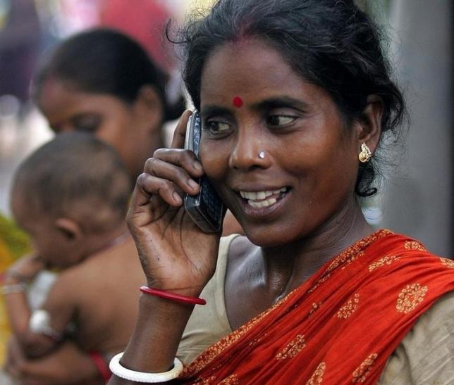 An Indian slum dweller uses a mobile phone in the eastern Indian city of Kolkata, August 23, 2005 (Reuters) 