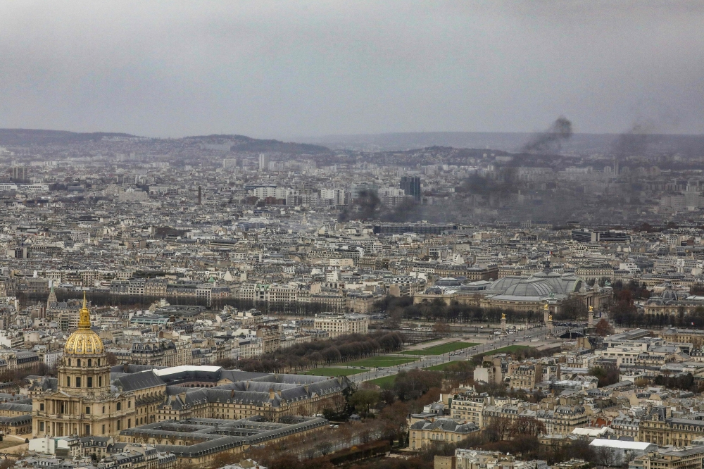 Black smoke rises above Paris buildings on December 8, 2018 during a protest of the 