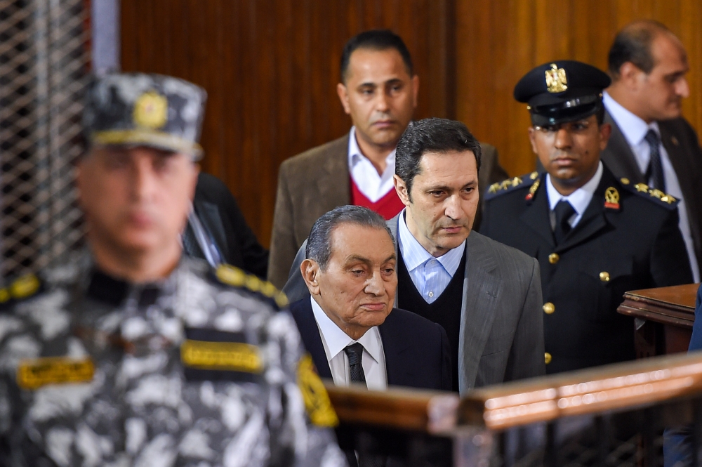 Former Egyptian president Hosni Mubarak (C, front), who was ousted following a popular uprisal in 2011, arrives with his sons Alaa (C-R) in southern Cairo on December 26, 2018. / AFP / MOHAMED EL-SHAHED
