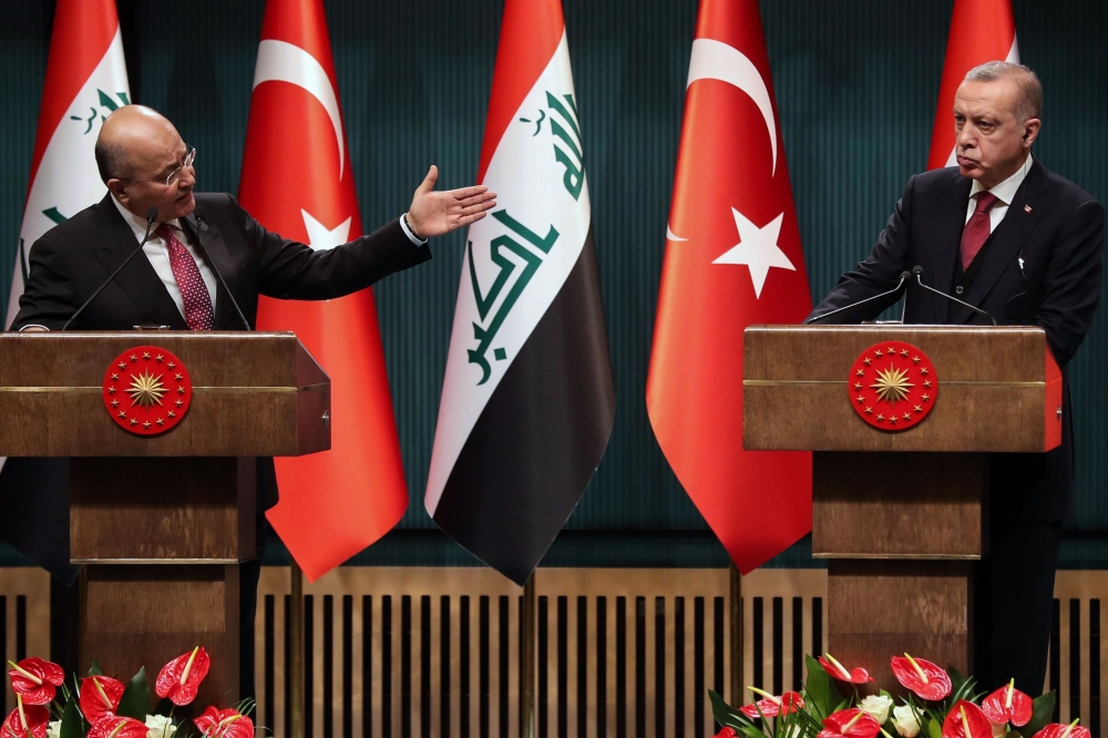Iraqi President Barham Salih (L), flanked by Turkish President Recep Tayyip Erdogan (R), gestures as he speaks during a joint press conference at the Presidential Complex in Ankara, on January 3, 2019. / AFP / ADEM ALTAN
