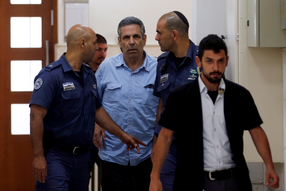 Gonen Segev, a former Israeli cabinet minister indicted on suspicion of spying for Iran, is escorted by prison guards as he arrives to court in Jerusalem, July 5, 2018. Reuters/Ronen Zvulun