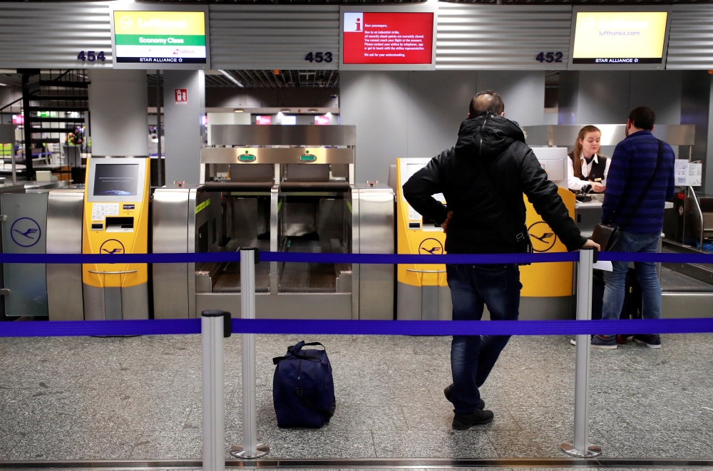 Stranded passenger get information at a check-in desk of German airline Lufthansa during a strike of security personnel over higher wages at Germany's largest airport in Frankfurt, Germany, January 15, 2019. REUTERS/Kai Pfaffenbach