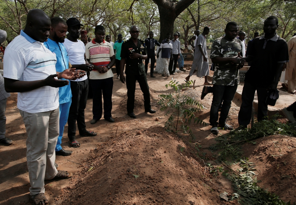Men pray over the grave of Ahmed Hussein-Suale, an investigative journalist who was killed by gunmen on Wednesday, inside a cemetery at Madina in Accra, Ghana January 18, 2019. Reuters/Francis Kokoroko