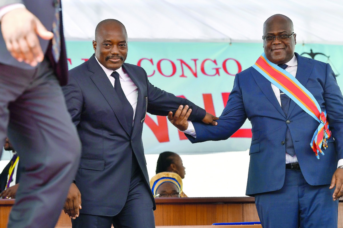 Democratic Republic of the Congo's newly inaugurated President Felix Tshisekedi (R) walks off the podium with outgoing President Joseph Kabila after he was officially handed over the instruments of power during his inauguration ceremony at the Presidency 