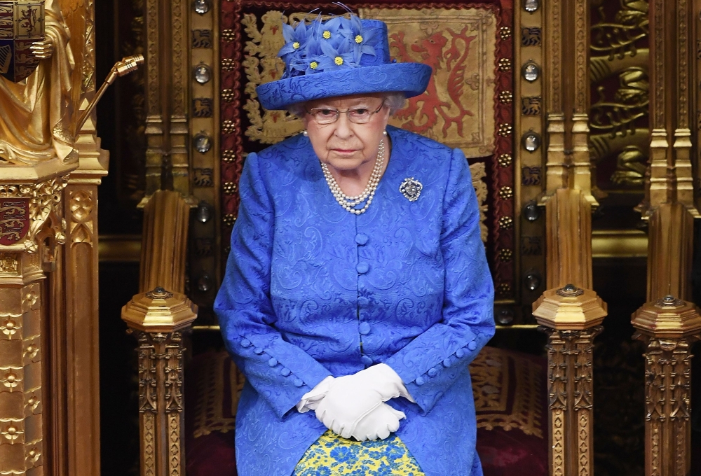 In this file photo taken on June 21, 2017 Britain's Queen Elizabeth II attends the State Opening of Parliament in the House of Lords at the Houses of Parliament in London on June 21, 2017.  / AFP / POOL / Carl Court 