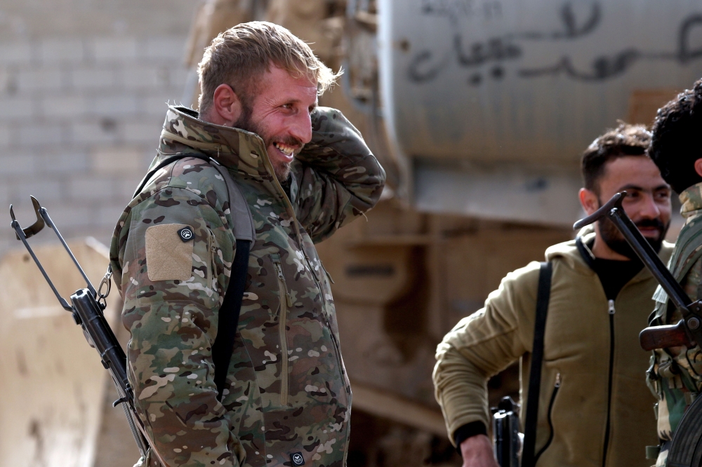 Fighters of the US-backed Kurdish-Arab coalition of the Syrian Democratic Forces (SDF) take a rest during an operation to expel Islamic State group (IS) jihadists from their last bastion, in Baghouz in the eastern Syrian province of Deir Ezzor on February