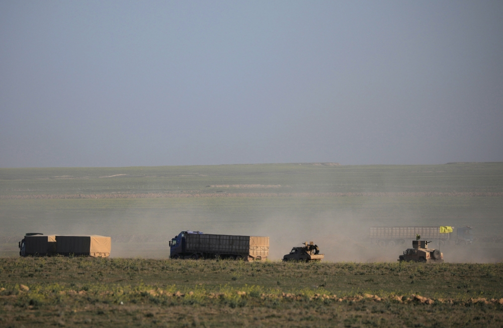 Trucks and a military vehicle for the Syrian Democratic Forces (SDF) move near Baghouz, Deir Al Zor, province, Syria, February 19, 2019. Reuters/Rodi Said