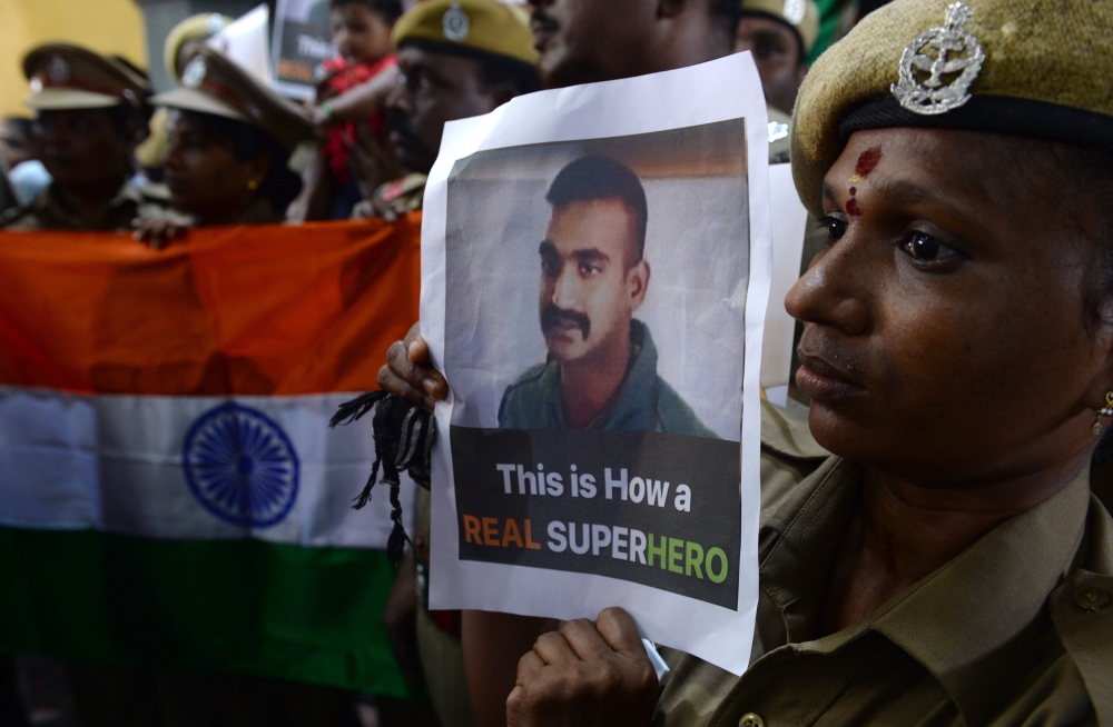 Indian security forces pose with the national flag and pictures of Indian Air Force pilot Abhinandan Varthaman during an event to pray for his return, at Kalikambal temple in Chennai on March 1, 2019.  AFP / Arun Sankar 