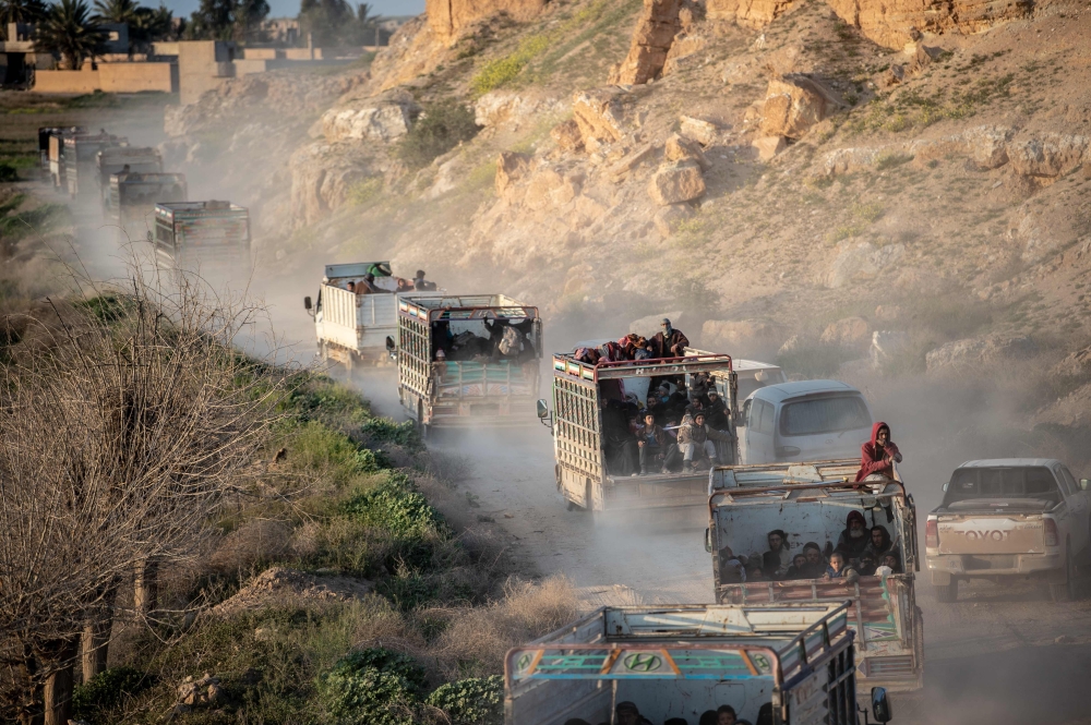 People who fled the Islamic State group's last holdout of Baghouz, in Syria's northern Deir Ezzor province, ride in the back of trucks in an area controlled by the Kurdish-led Syrian Democratic Foces (SDF) on March 4, 2019.  AFP / Bulent KILIC