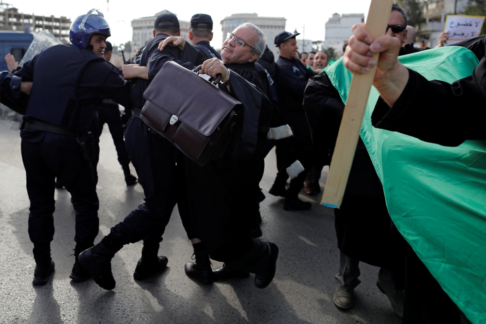 Police attempt to disperse lawyers trying to force their way to the constitutional council during a protest to denounce an offer by President Abdelaziz Bouteflika to run in elections next month but not to serve a full term if re-elected, in Algiers, Alger