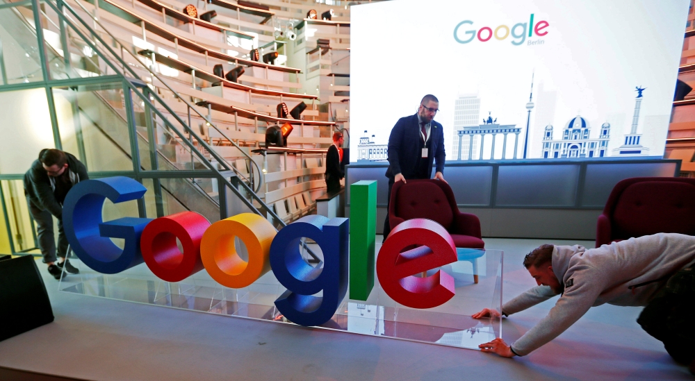 FILE PHOTO: Workers move a Google logo during the opening of the new Alphabet's Google Berlin office in Berlin, Germany, January 22, 2019. REUTERS/Hannibal Hanschke
