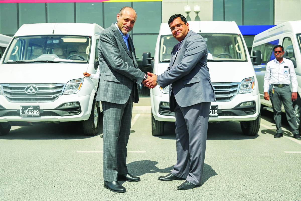 The officials shaking hands at the deal signing ceremony.
