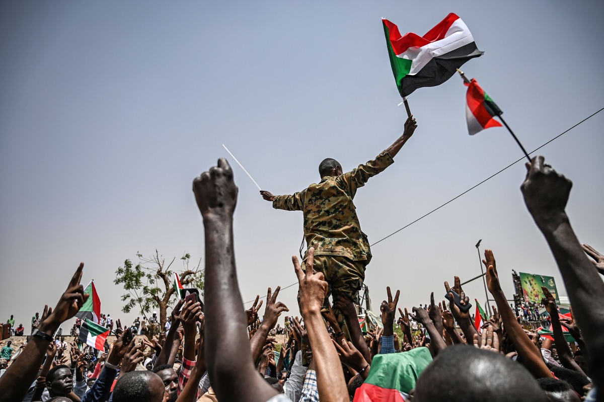  Sudanese protestors shout slogans as they carry a Sudanese officer during a protest outside the army complex in the capital Khartoum on April 18, 2019.  AFP / Ozan Kose