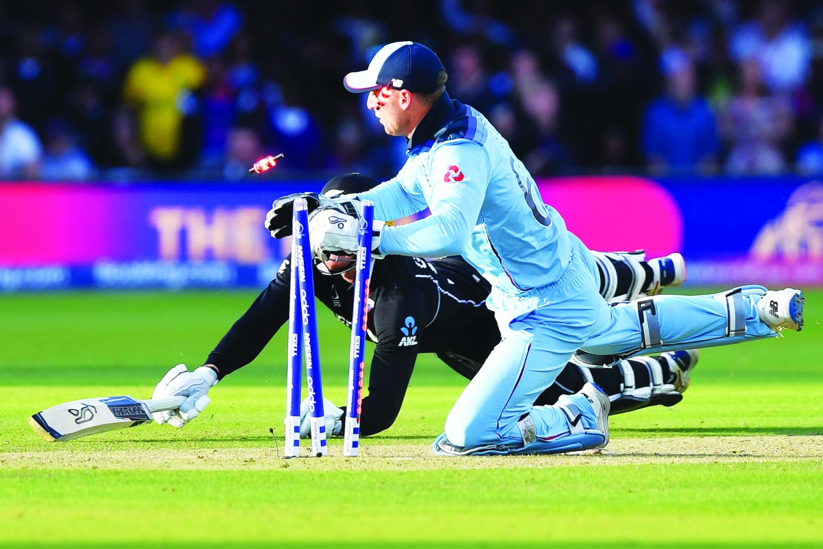 England's Jos Buttler runs out New Zealand's Martin Guptill to win the super-over to win the 2019 Cricket World Cup final between England and New Zealand at Lord's Cricket Ground in London on July 14, 2019.  AFP / Paul Ellis